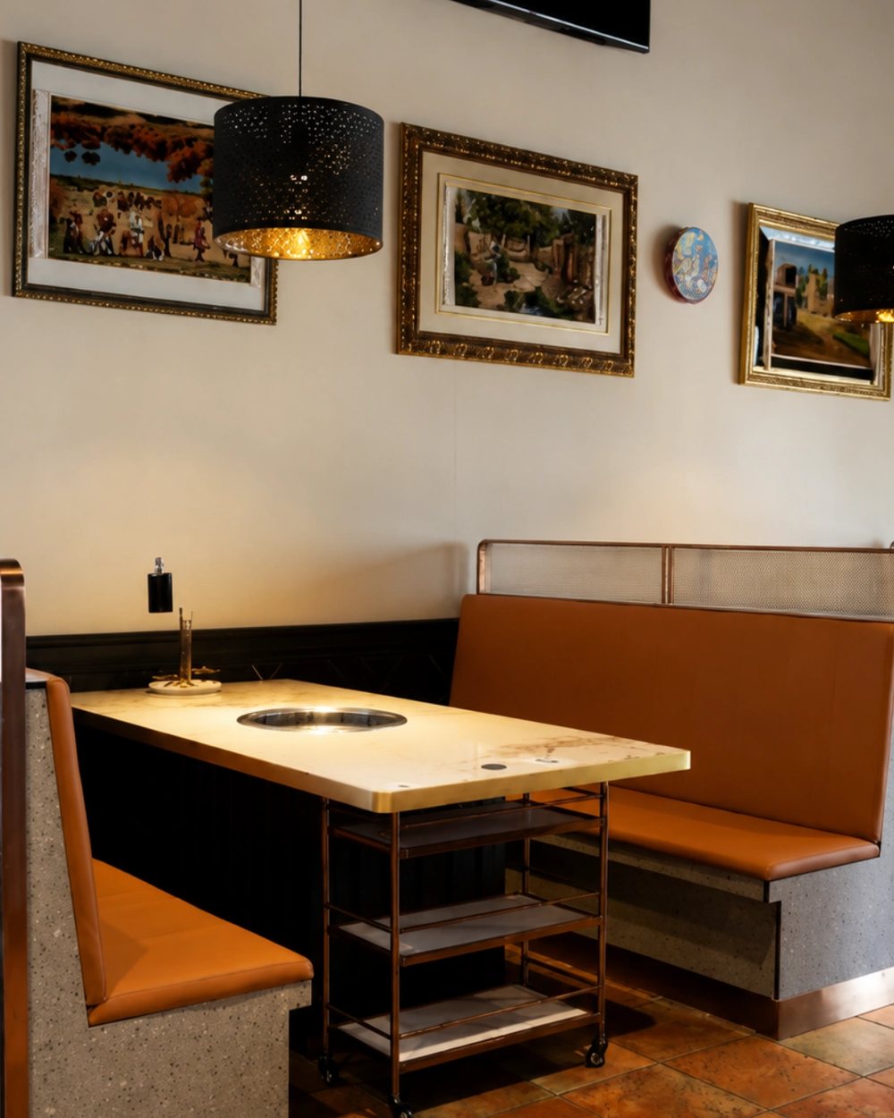 An orange booth with an induction pot set into the table