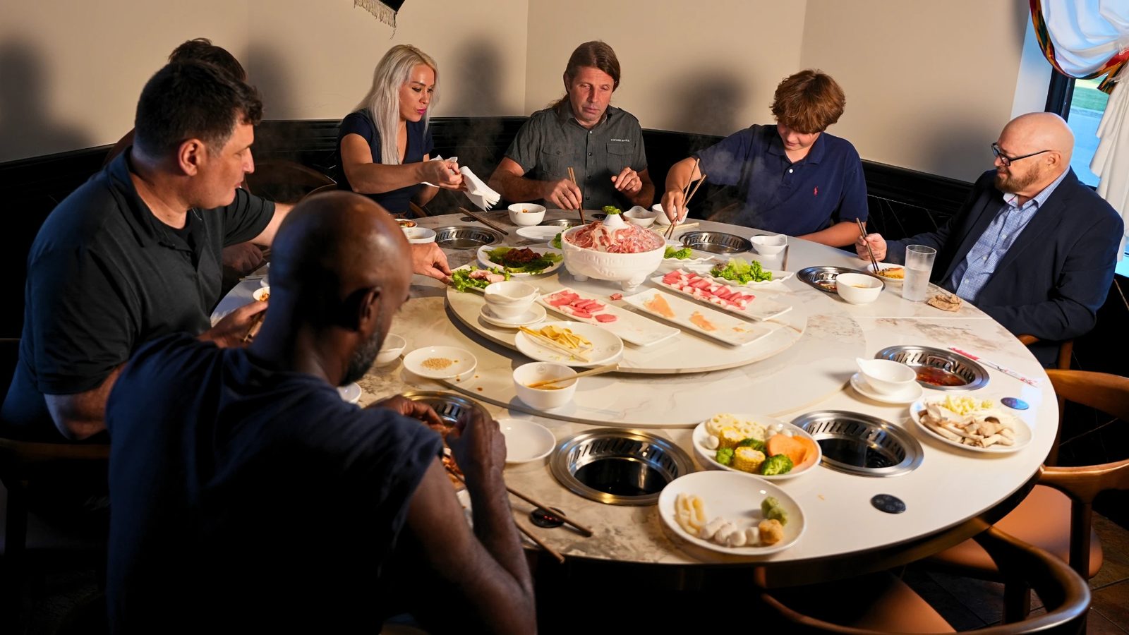 A long table of guests sharing hot pot at Otluk Hot Pot