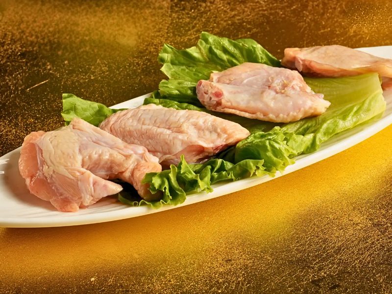 Fresh chicken wings plated on lettuce